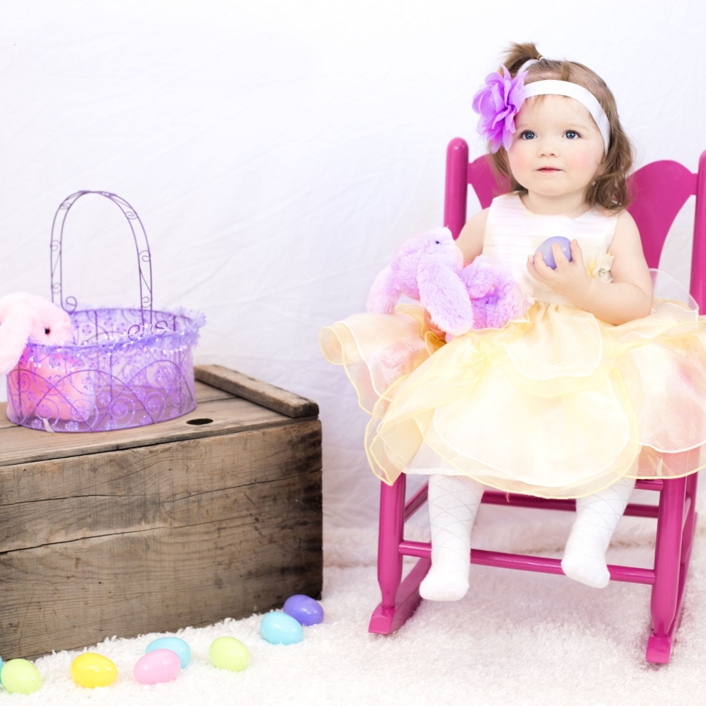 Девочка в красивом платье сидит на стуле 