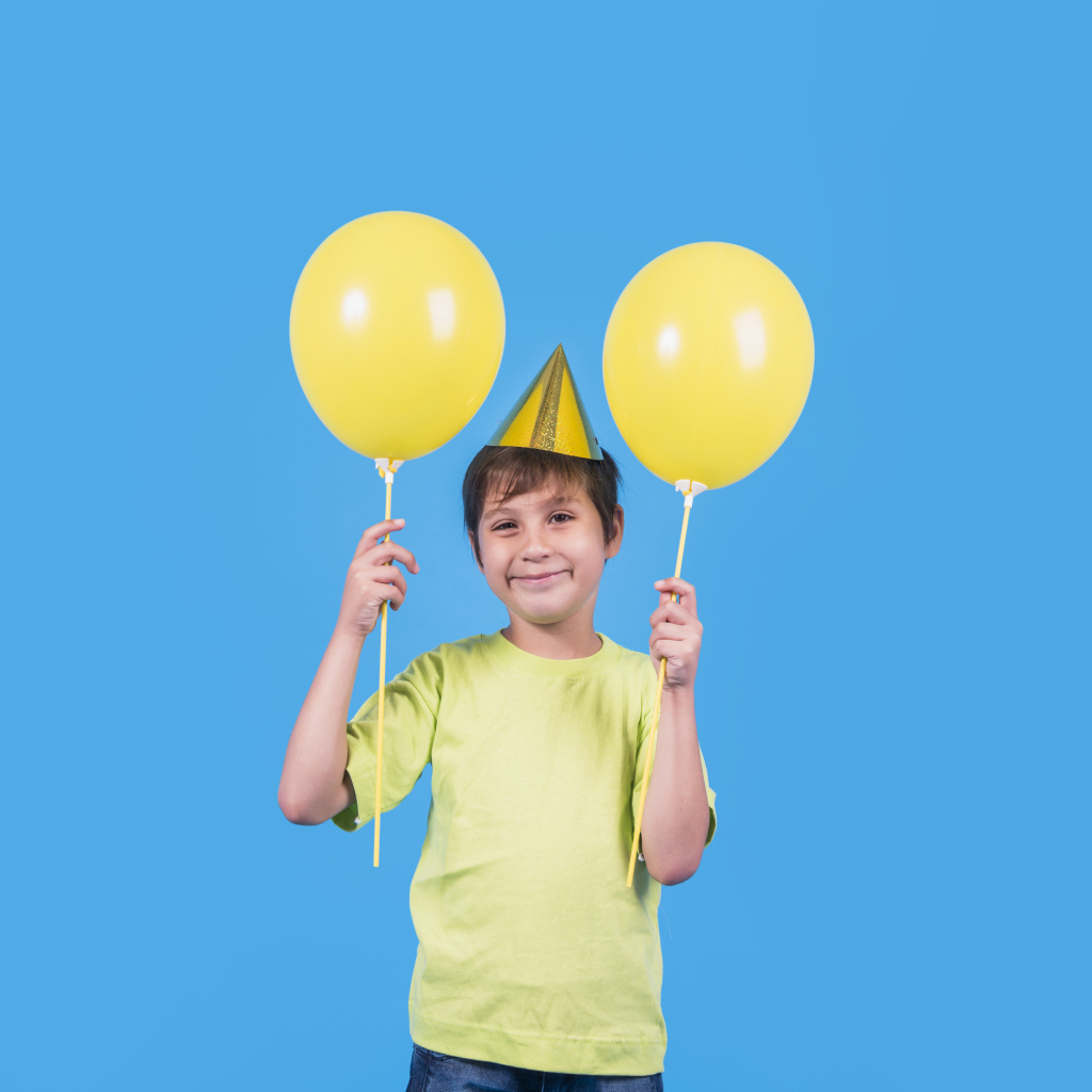 Мальчик на день рождения с желтыми шариками