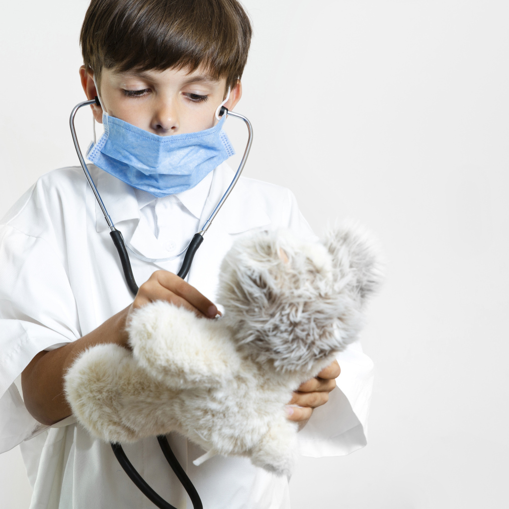 Мальчик в костюме врача с игрушечным медведем