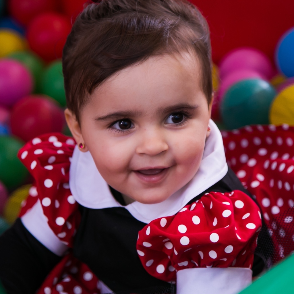 Кареглазая девочка в бассейне с шариками