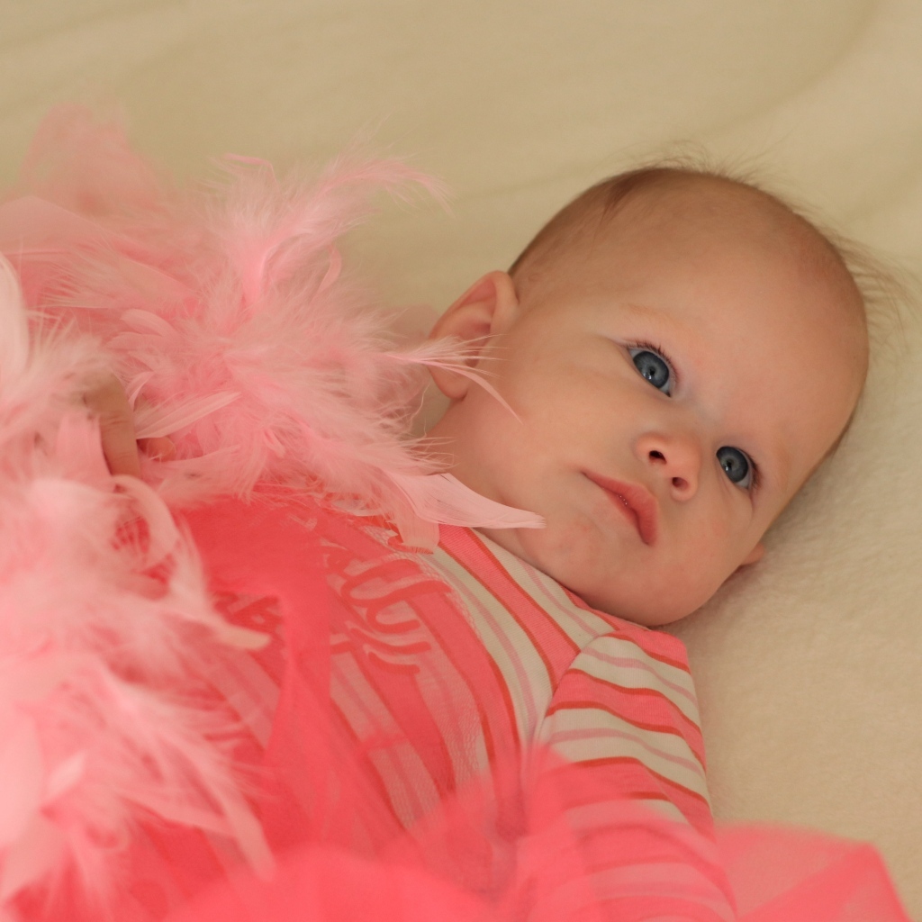 Милая малышка с розовыми перьями