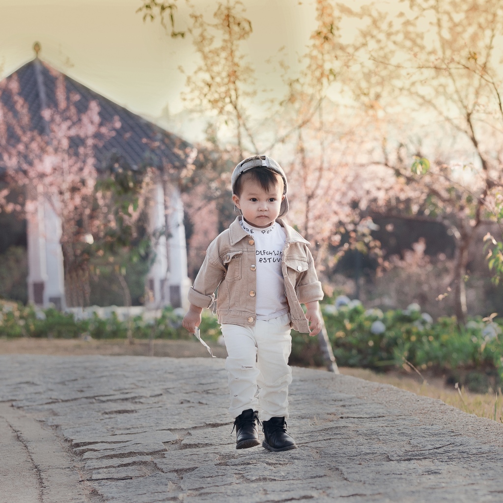 Милый мальчик гуляет по дороге у дома