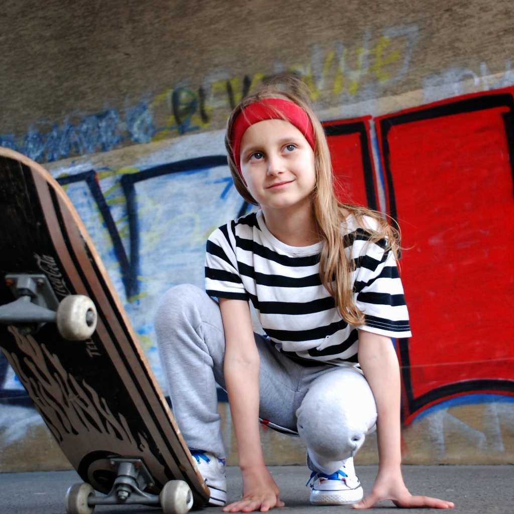 Милая маленькая девочка со скейтбордом