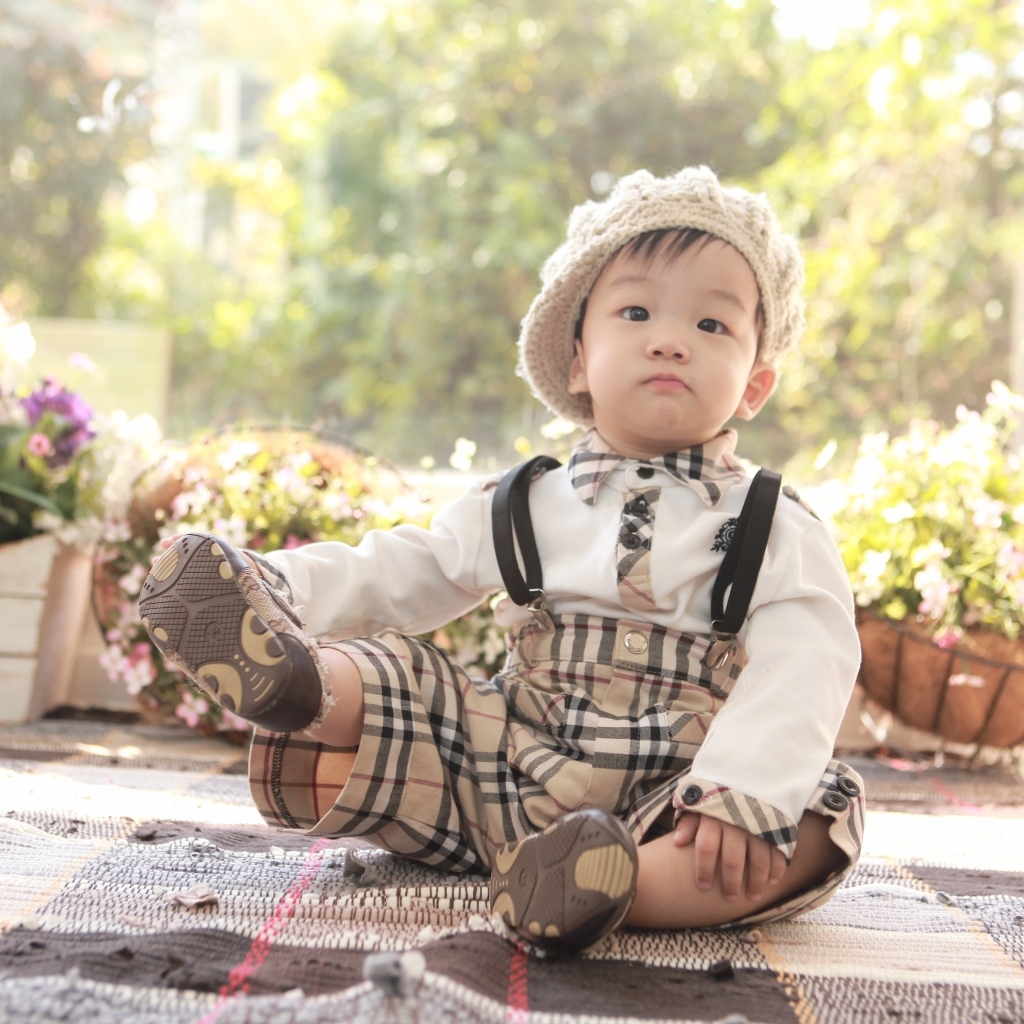 Смешной мальчик азиат у цветов