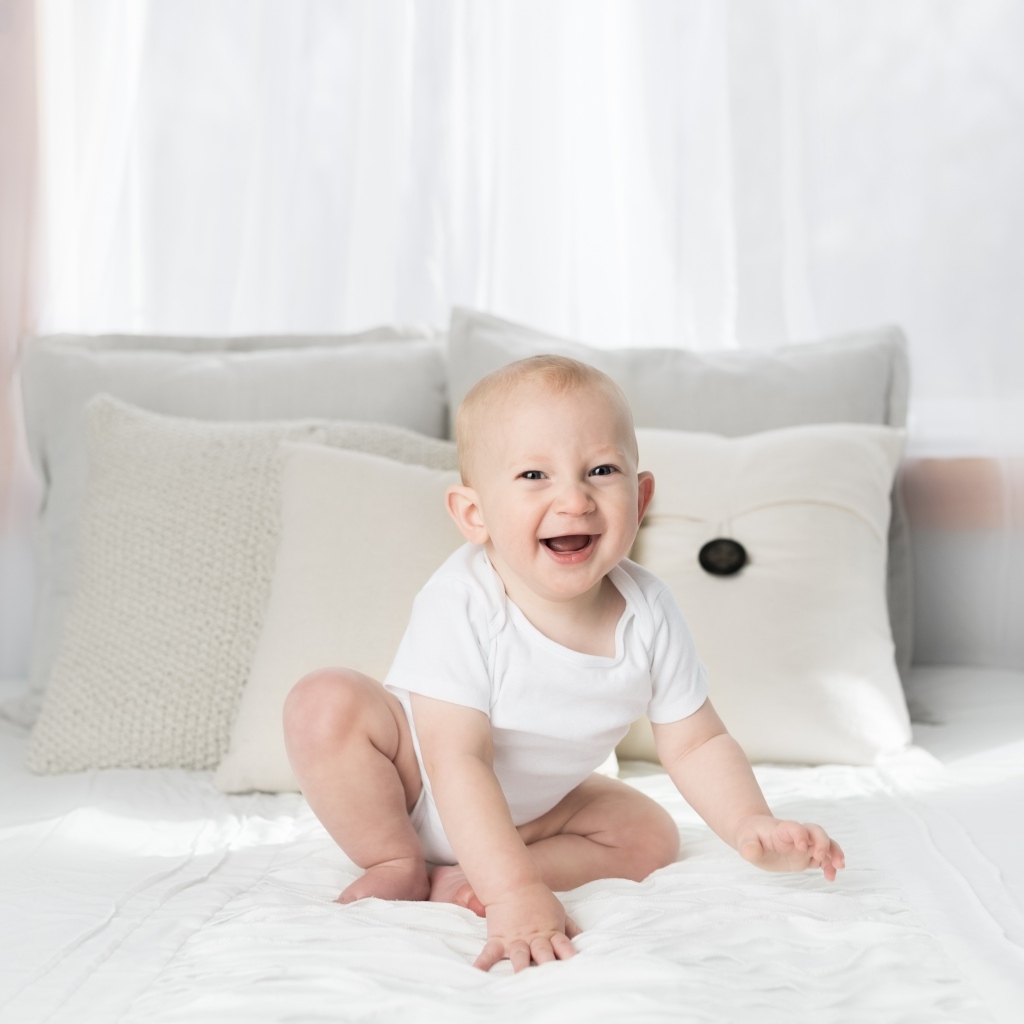 Смешной маленький ребенок на кровати