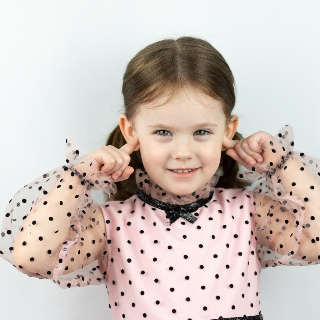 Смешная маленькая девочка закрыла уши