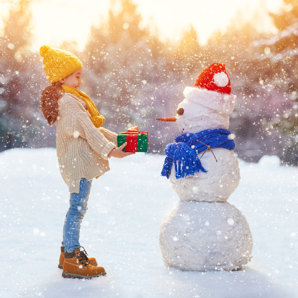 Девочка дарит подарок снеговику