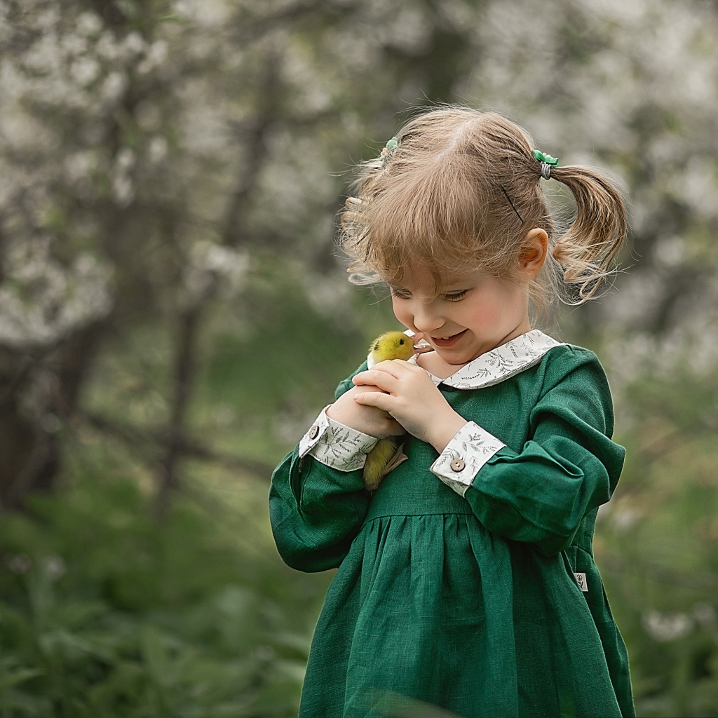 Девочка в зеленом платье с утенком в руках