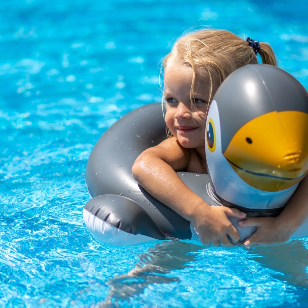 Девочка со спасательным кругом в бассейне