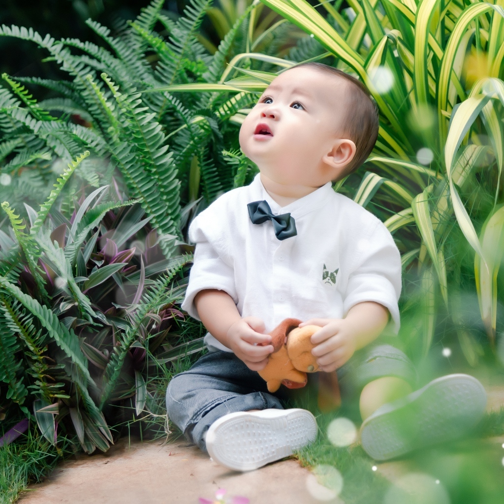 Маленький азиатский ребенок в зеленой траве