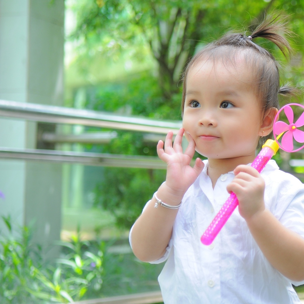 Маленькая девочка азиатка с игрушкой в руках