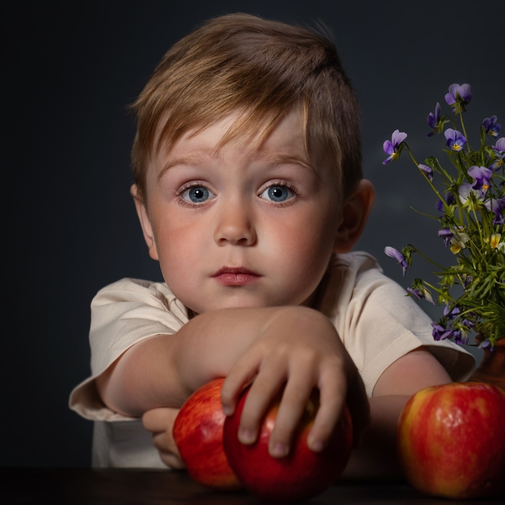 Маленький голубоглазый мальчик с яблоками