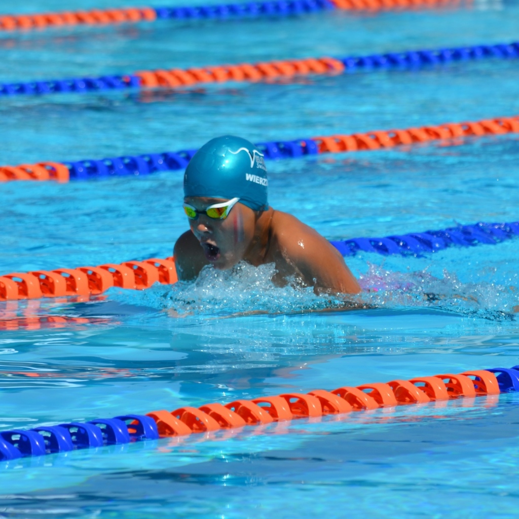 Маленький мальчик пловец в бассейне