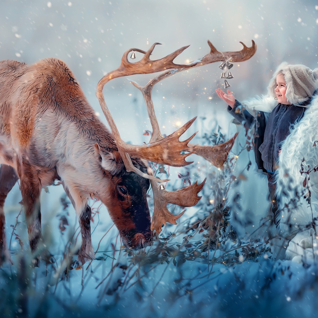 Маленький мальчик с оленем на природе зимой