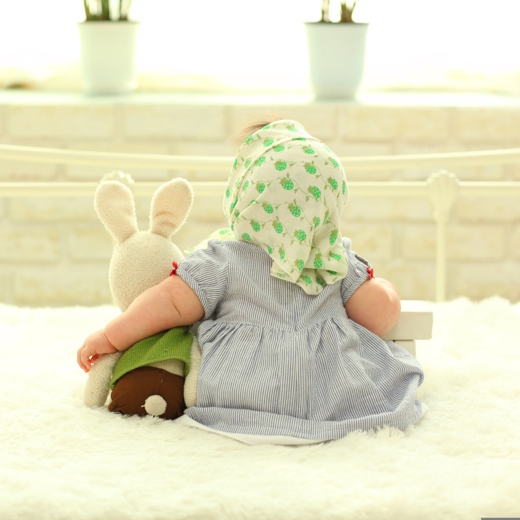 Маленькая девочка обнимает игрушечного зайца