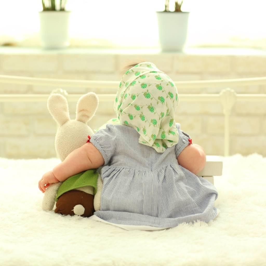 Маленькая девочка сидит с игрушкой