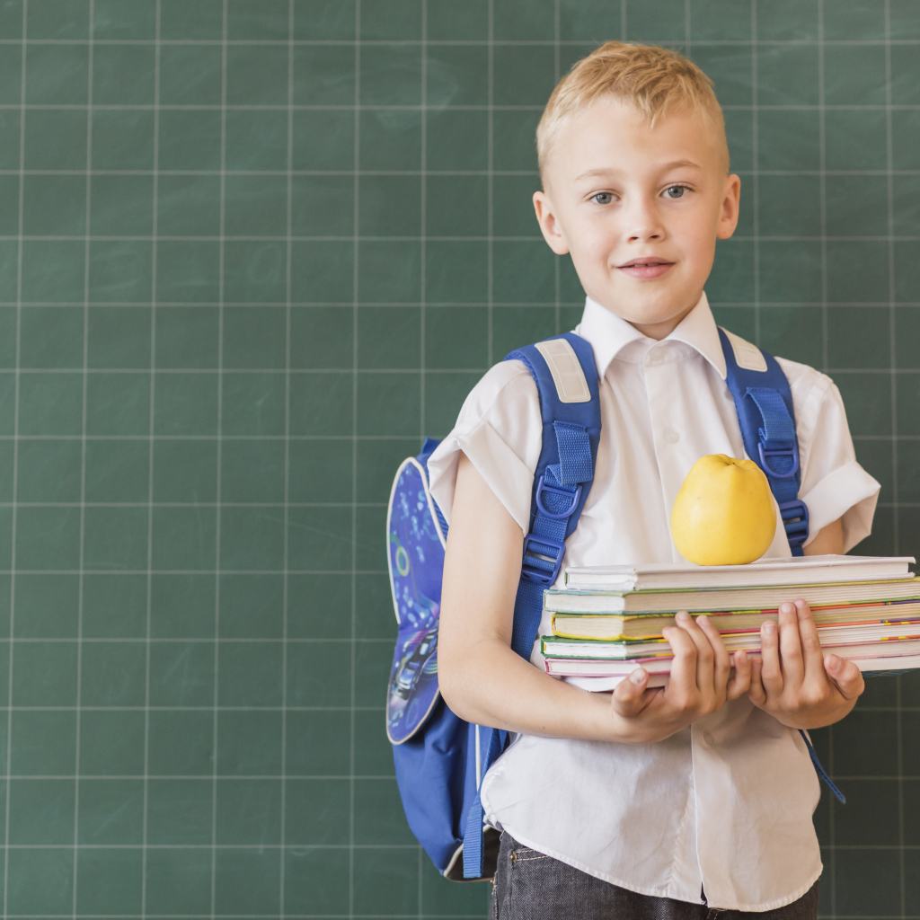 Мальчик школьник с книгами у доски