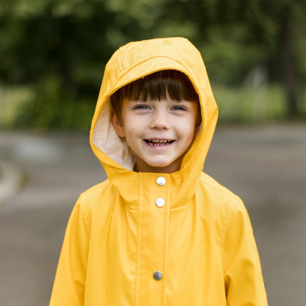 Улыбающийся мальчик в желтой куртке