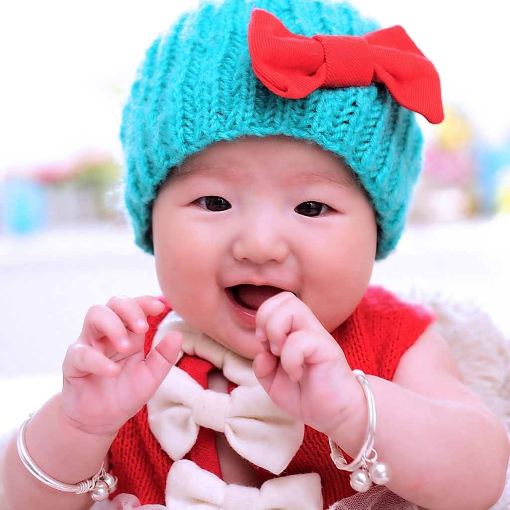 Улыбающаяся девочка в зеленой вязаной шапке