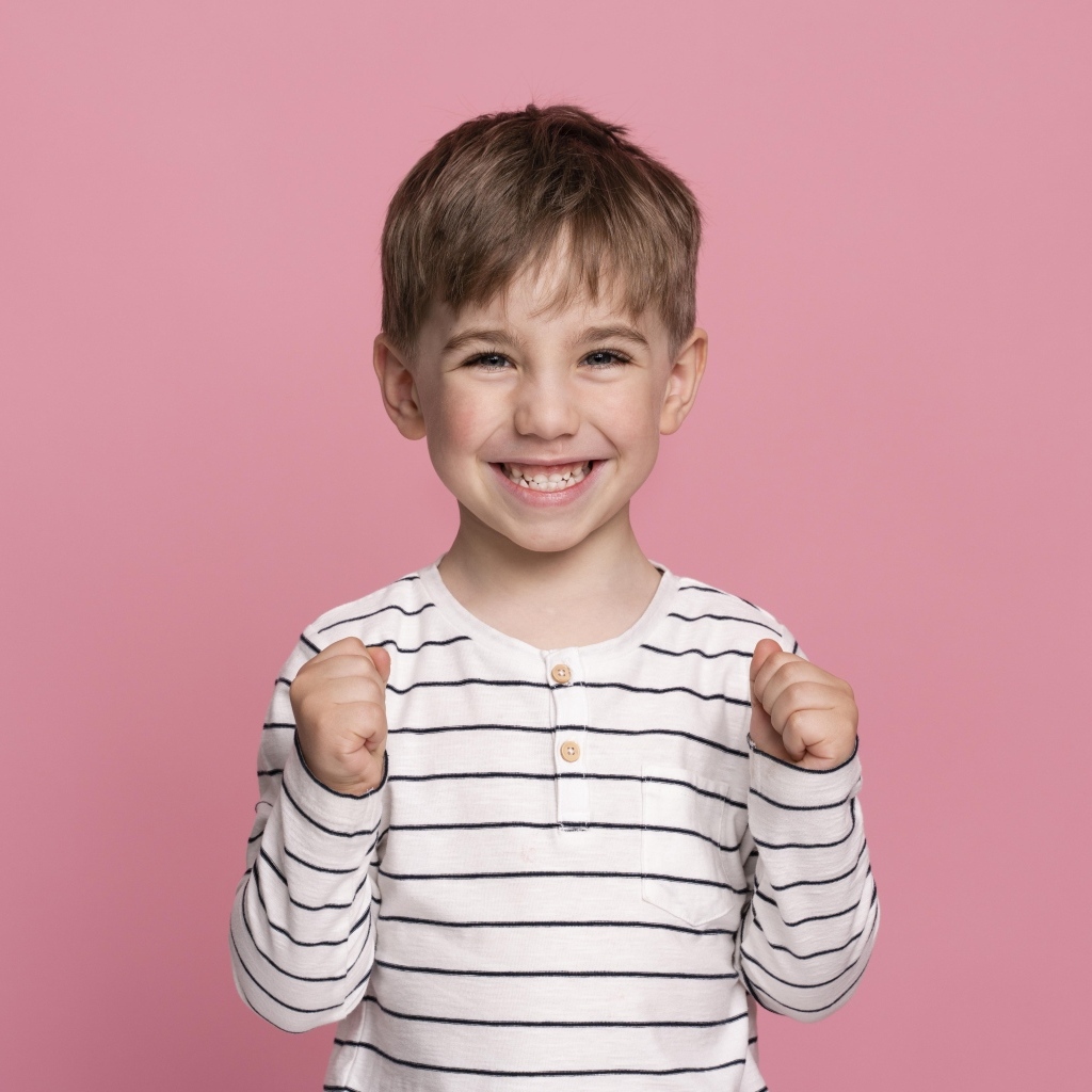 Улыбающийся маленький мальчик на сиреневом фоне