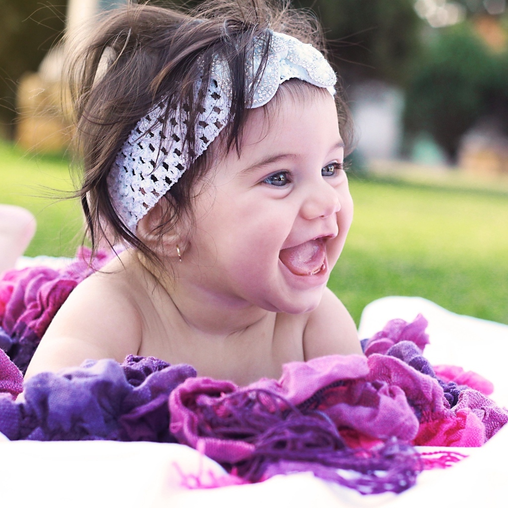 Улыбающаяся маленькая девочка с повязкой на голове 