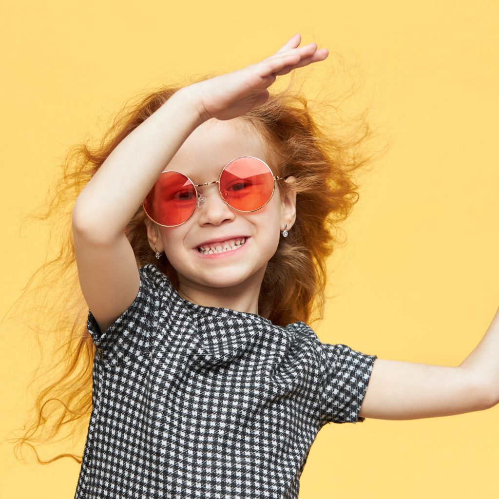 Улыбающаяся рыжеволосая девочка в очках