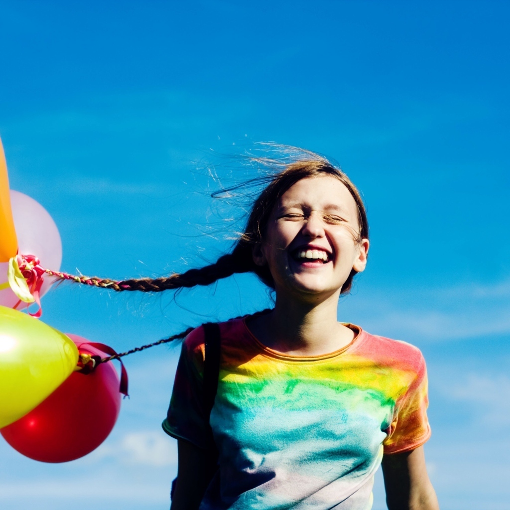 У веселой девочки шарики привязаны к косам