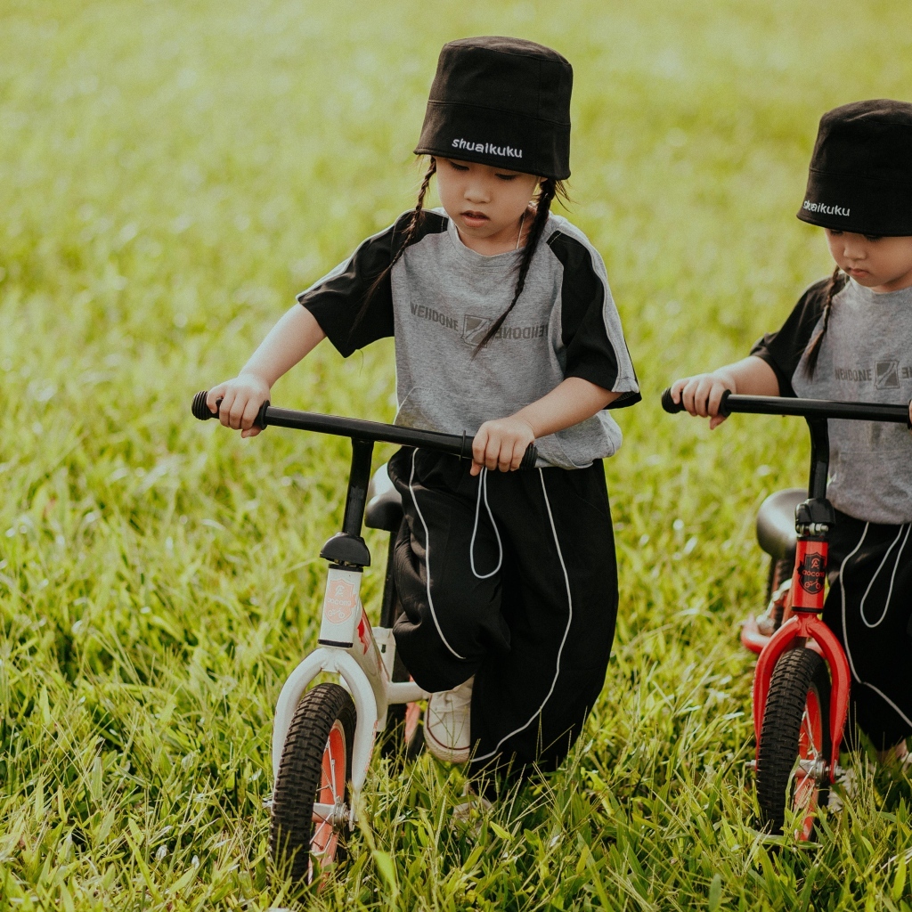 Две девочки с велосипедами на зеленой траве