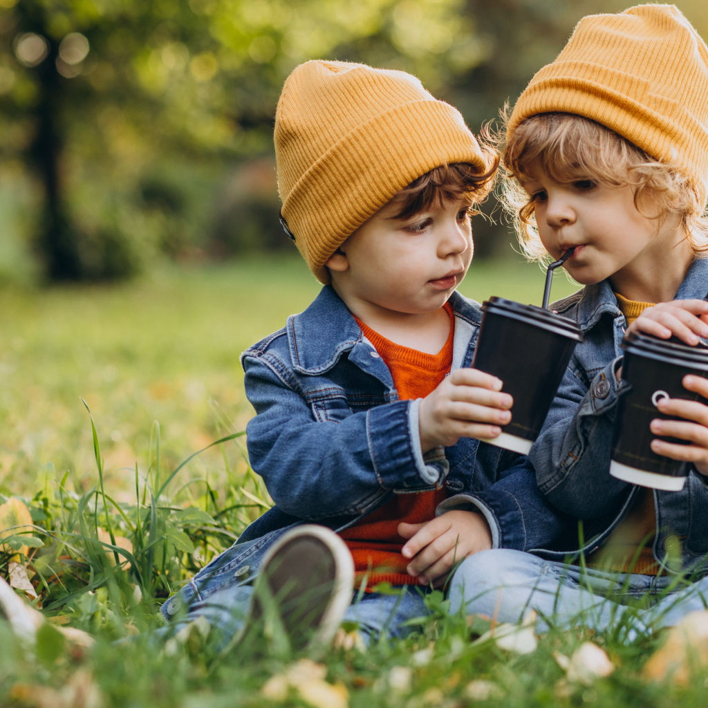 Два маленьких  брата сидят на траве