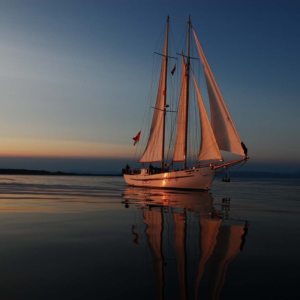 Большая парусная яхта в море на закате