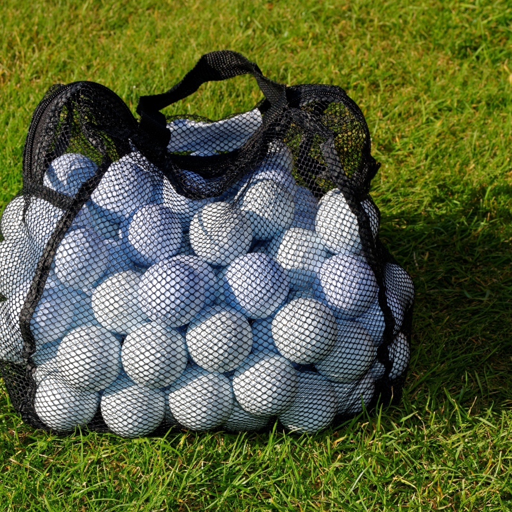 Сетка с мячами для гольфа на траве