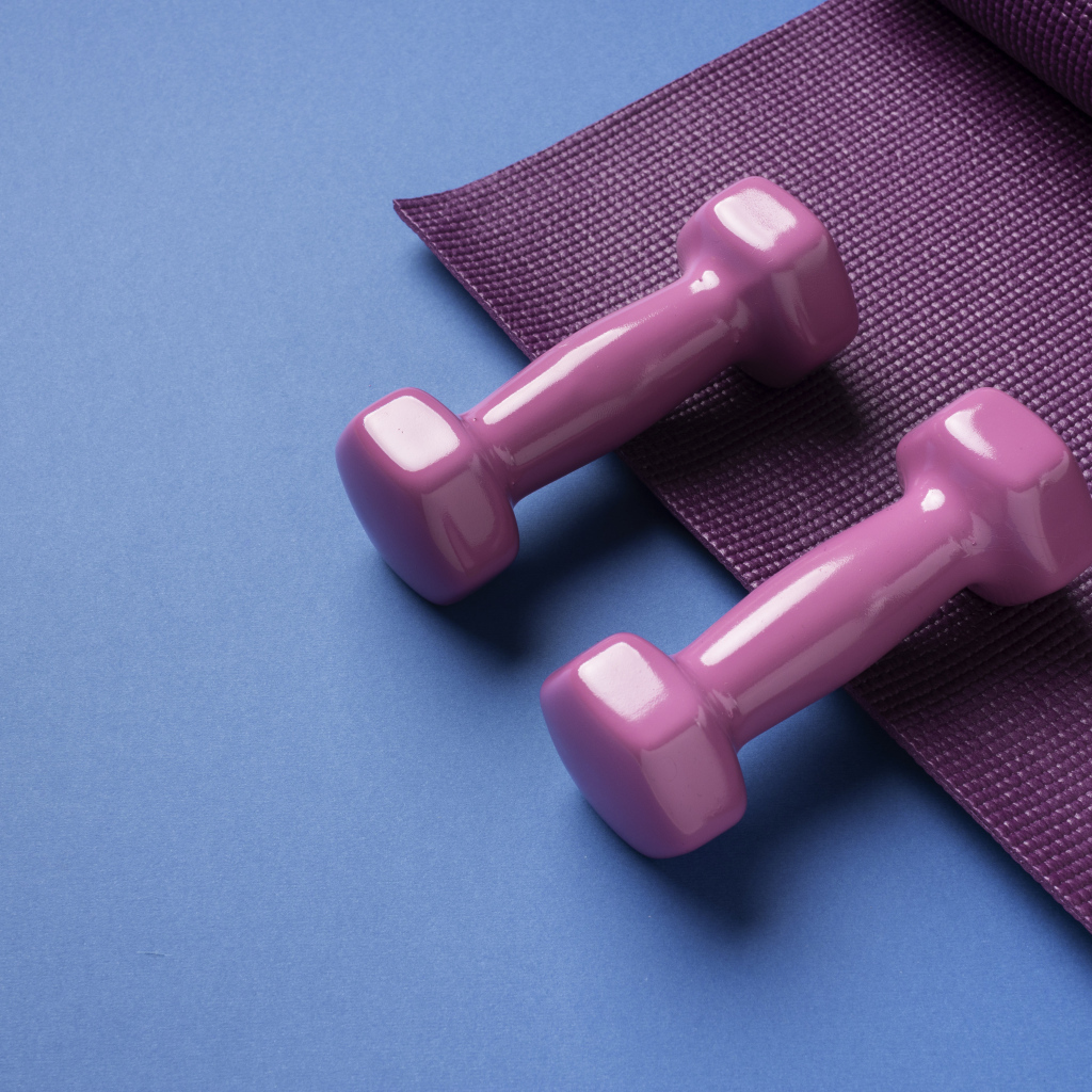 Розовые гантели и коврик на голубом фоне