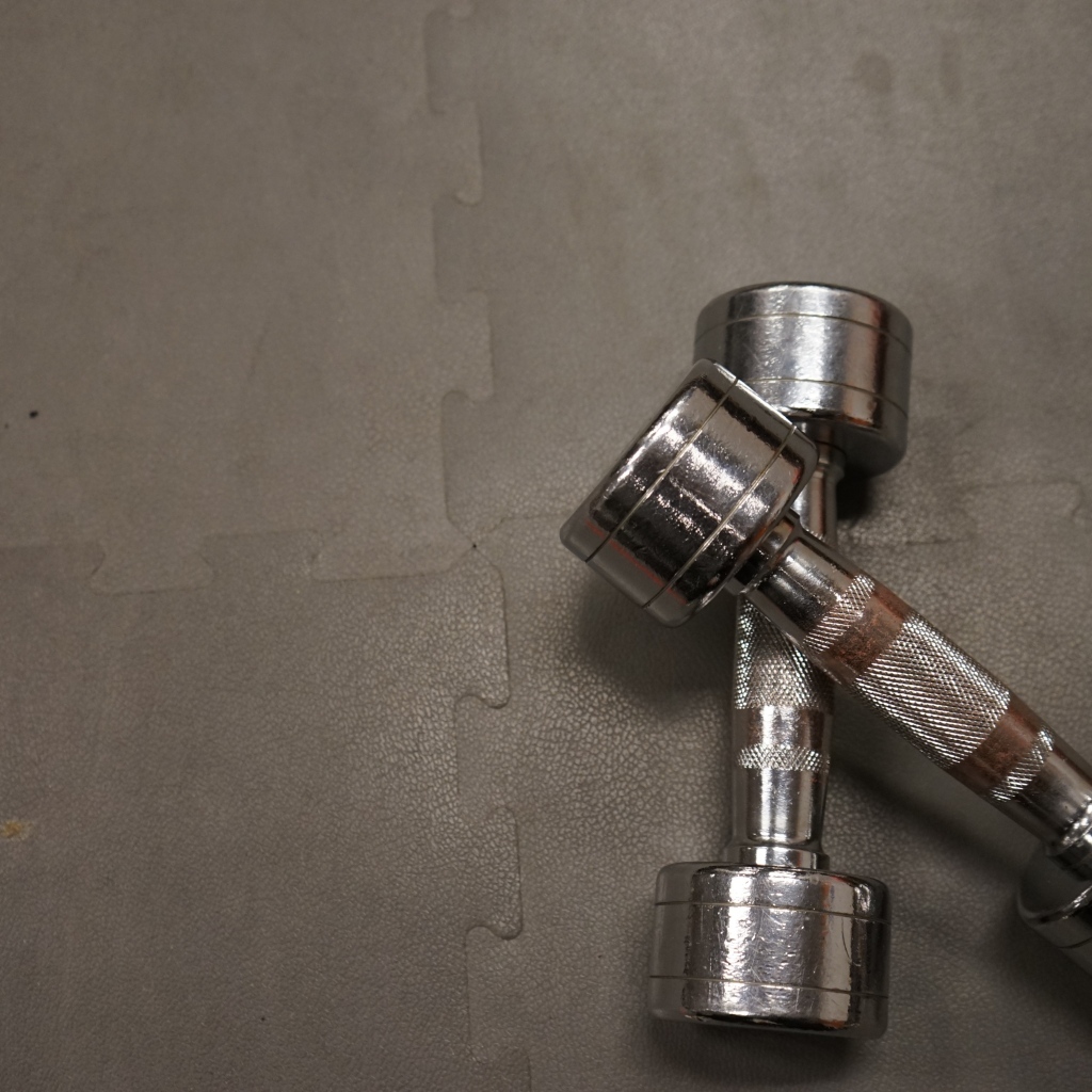 Две железные гантели на сером фоне