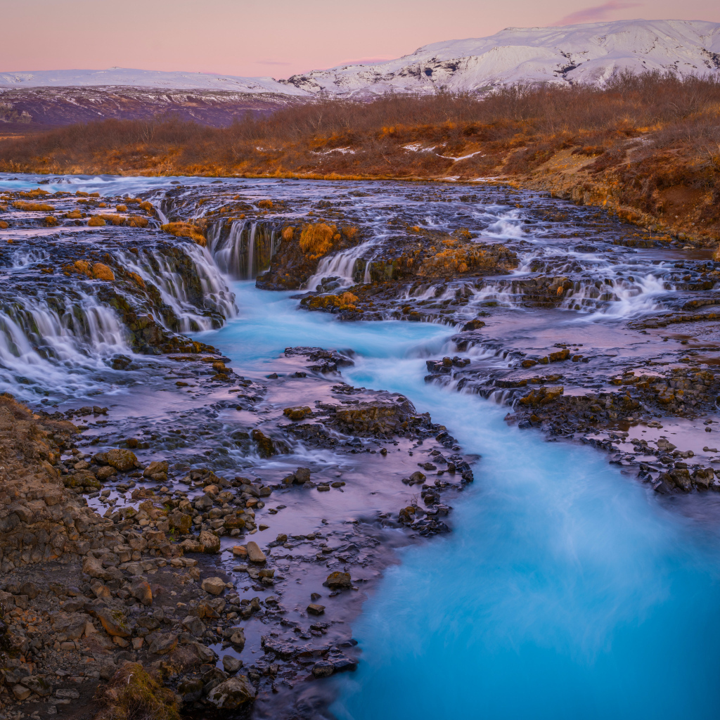 Быстрая река стекает по камням в горах Исландии