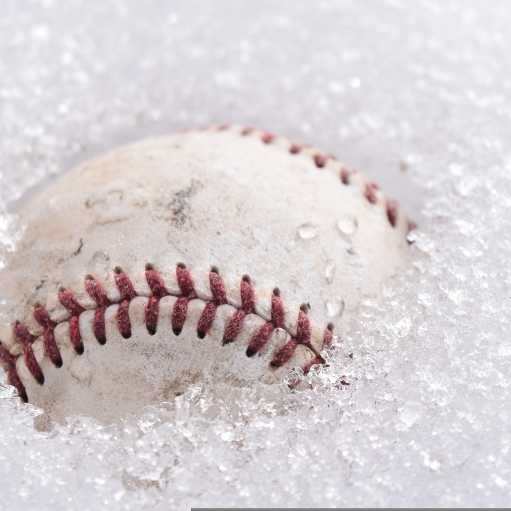 Бейсбольный мяч лежит в белом снегу
