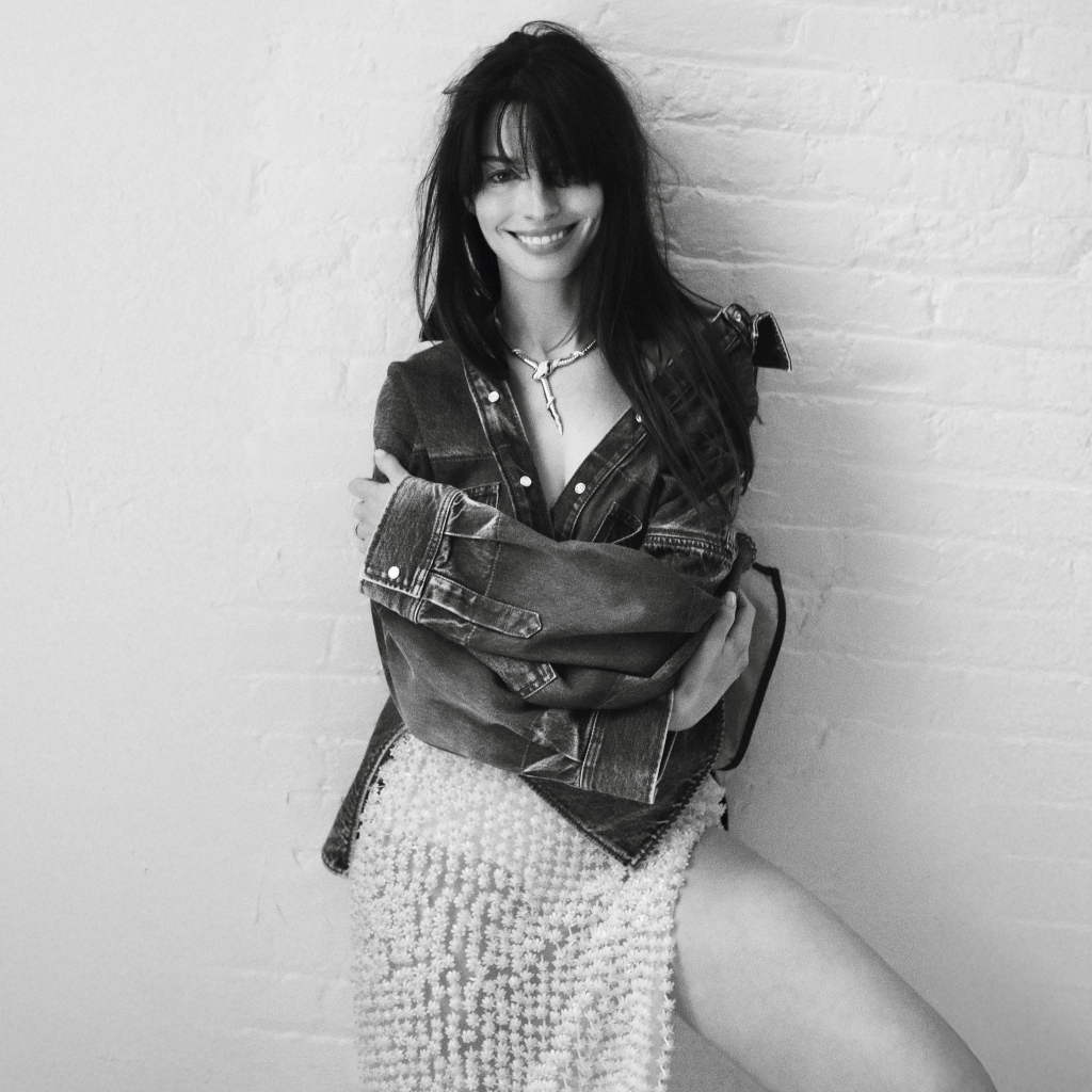 Актриса Энн Хэтэуэй стоит у стены черно-белое фото