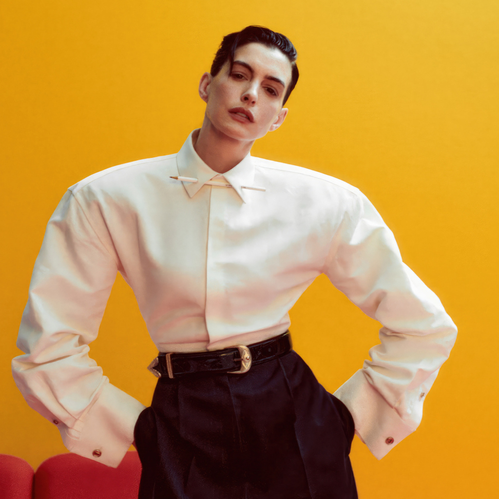 Актриса Энн Хэтэуэй в белой рубашке на желтом фоне