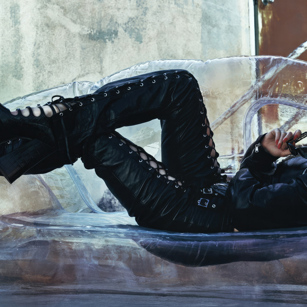 Актриса Аня Тейлор-Джой в черном костюме лежит на диване