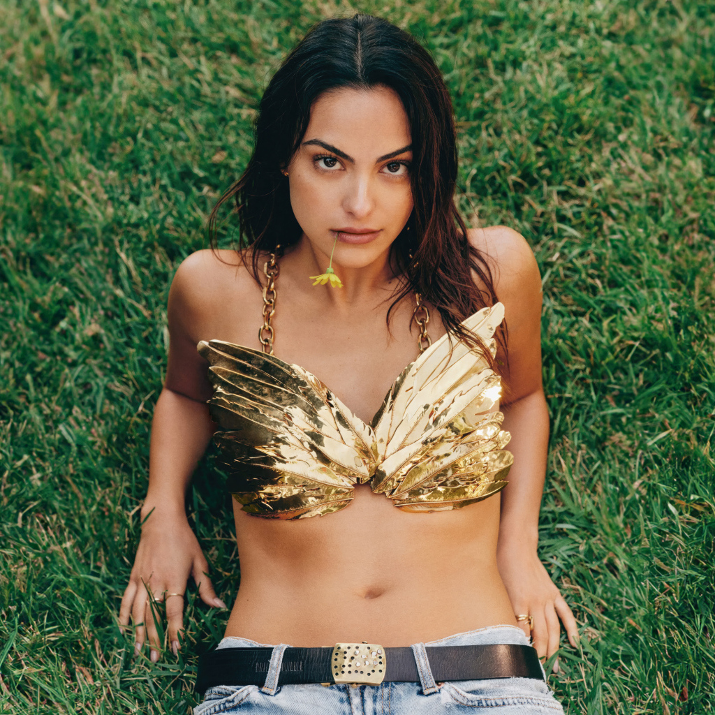 Актриса Камила Мендес лежит на зеленой траве