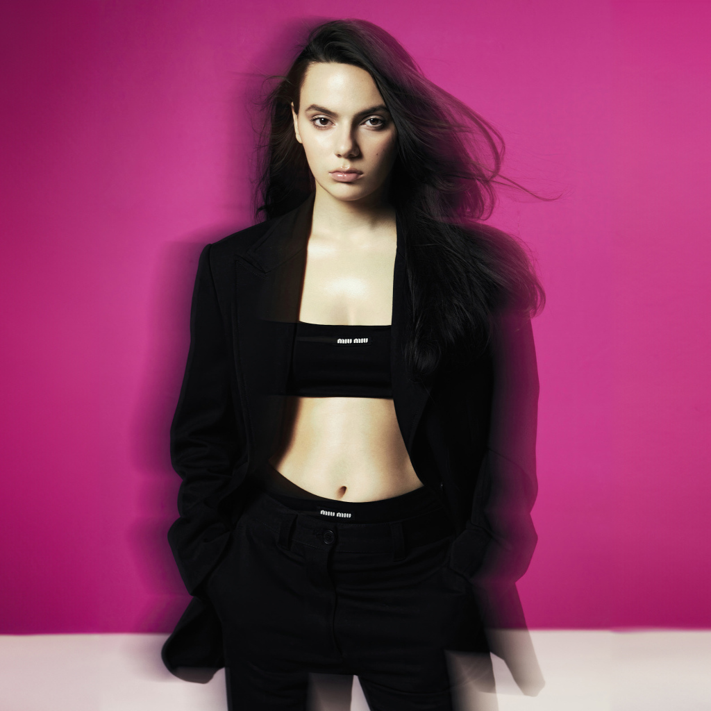 Актриса Дафни Кин стоит у розовой стены