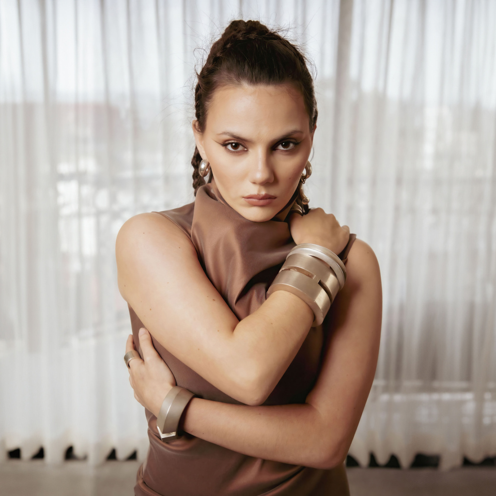 Актриса Дафни Кин с браслетами на руках у окна