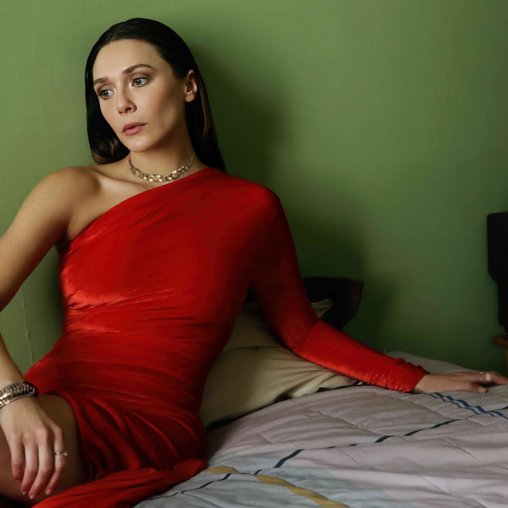 Актриса Элизабет Олсен в красном платье сидит на кровати