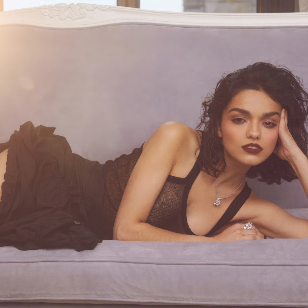 Актриса Рэйчел Зеглер в черном платье лежит на диване