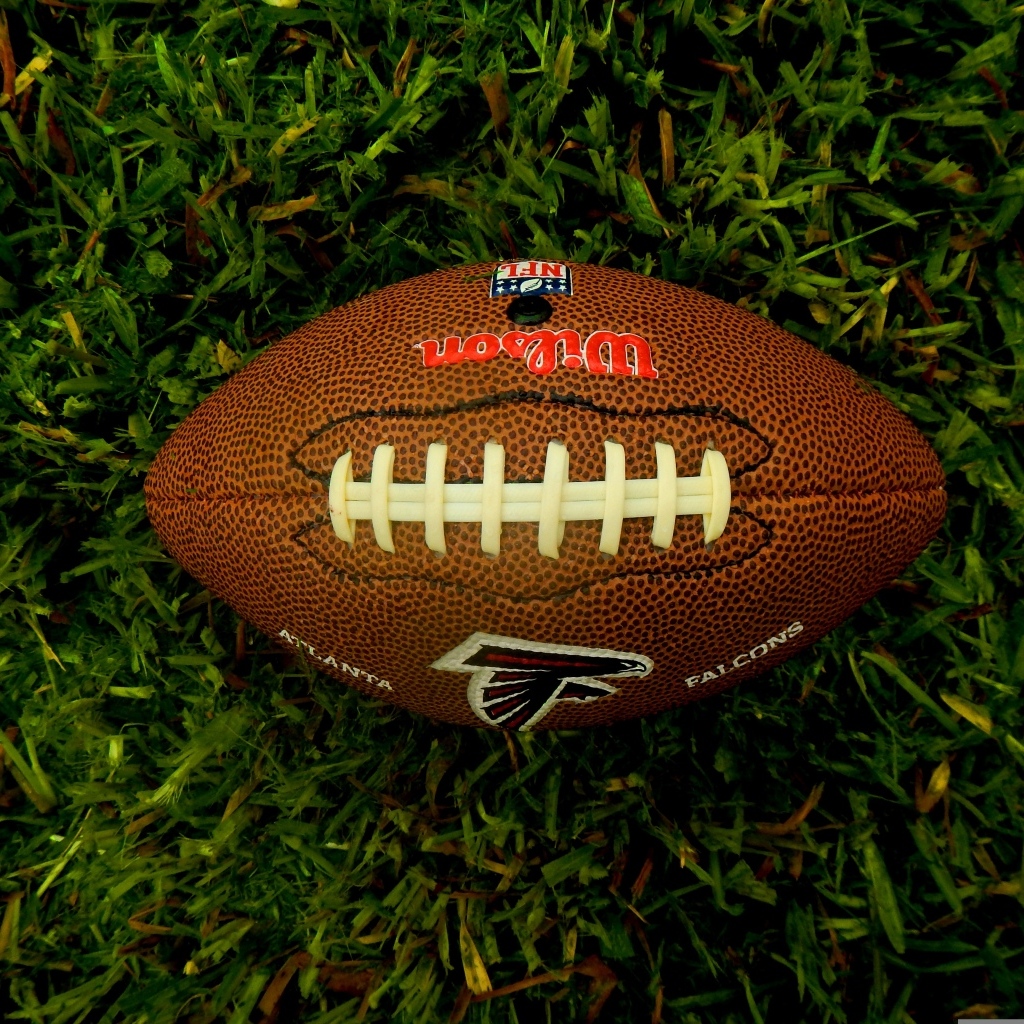 Мяч для игры в американский футбол на зеленой траве