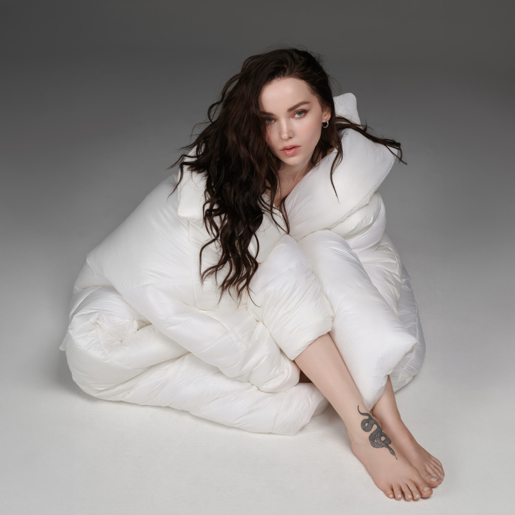 Красивая брюнетка Дав Кэмерон в белом костюме на сером фоне