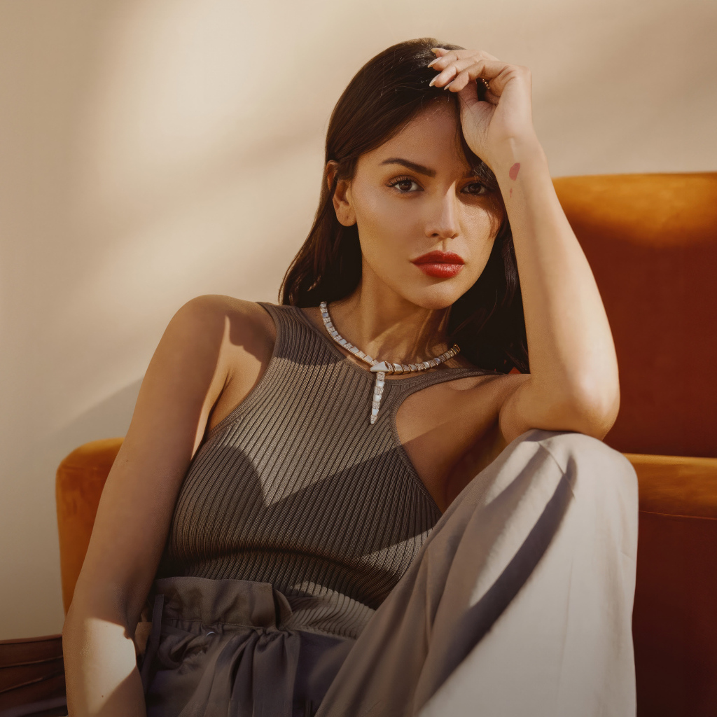 Красивая брюнетка, актриса Эйса Гонсалес сидит у дивана