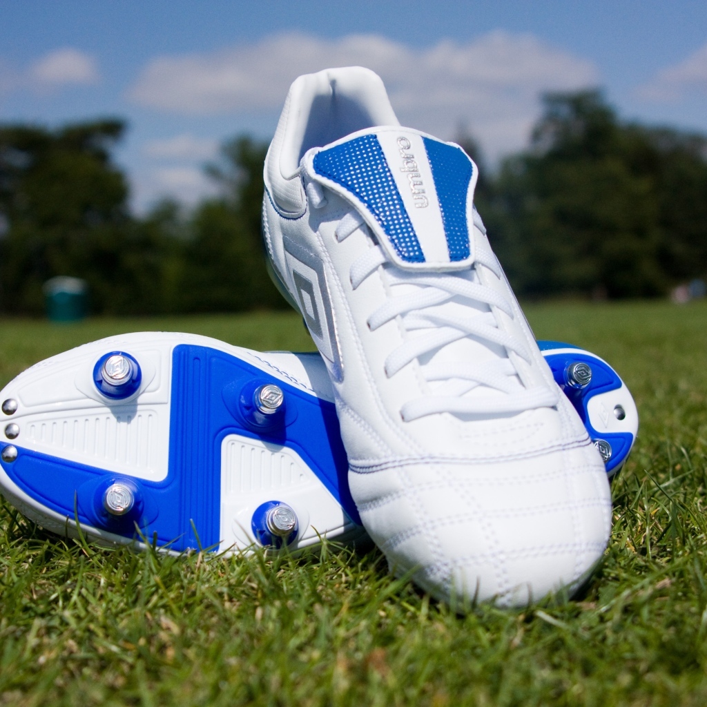 Красивые новые футбольные бутсы на зеленой траве 