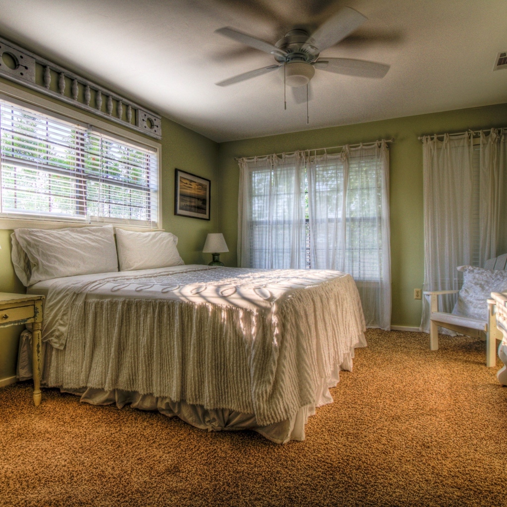 Спальня в зеленых тонах с высокой кроватью 