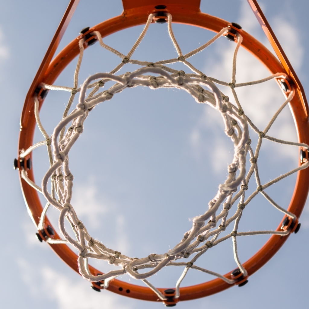 Вид снизу на баскетбольное кольцо на фоне неба