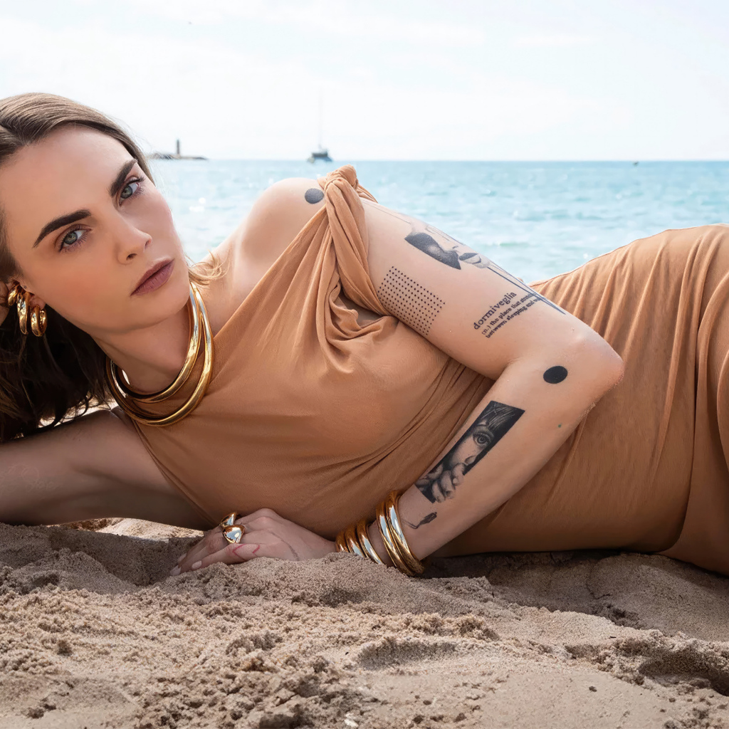 Британская актриса Кара Делевинь лежит на песке на пляже